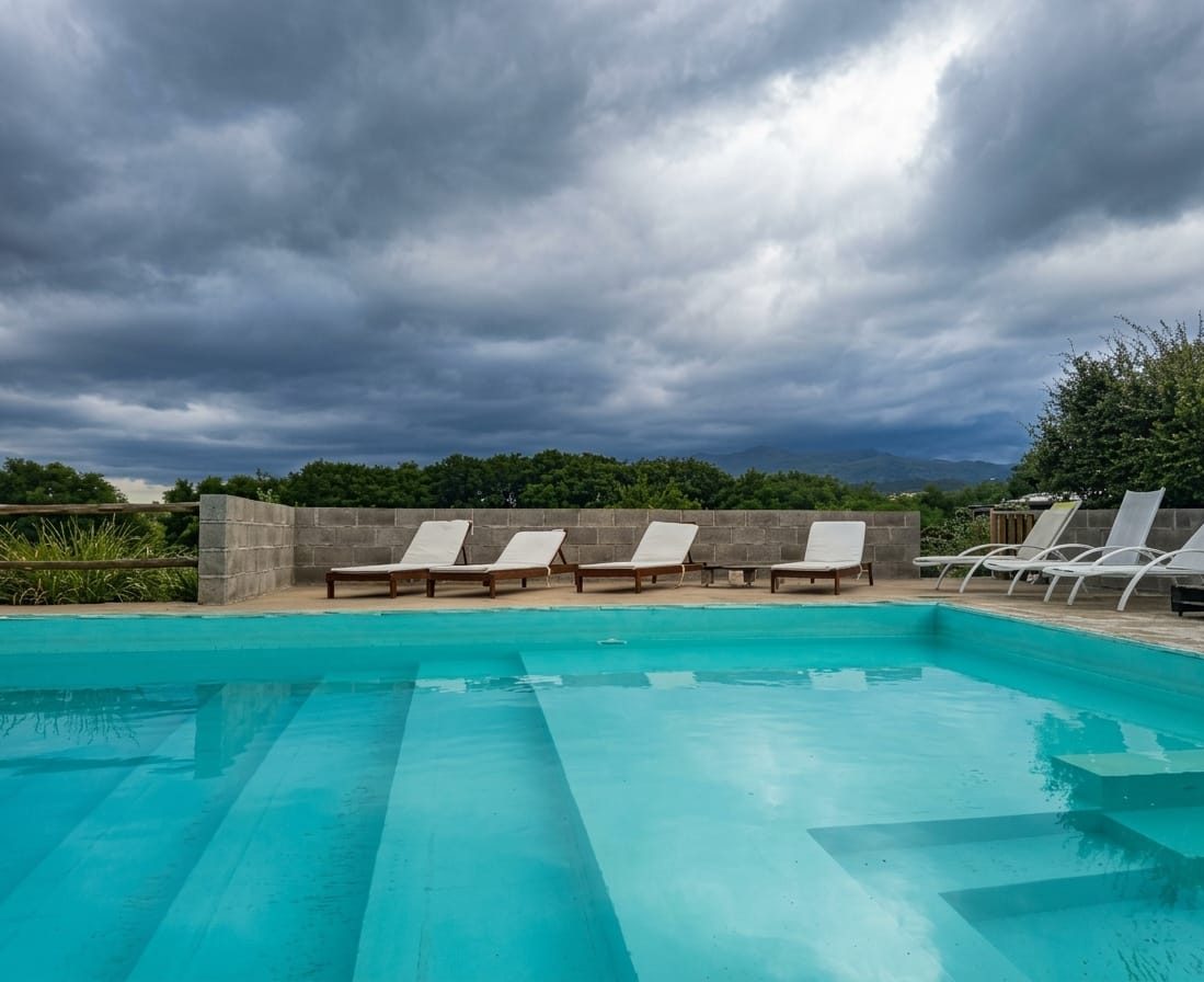 La piscina y el solárium con el cielo nublado